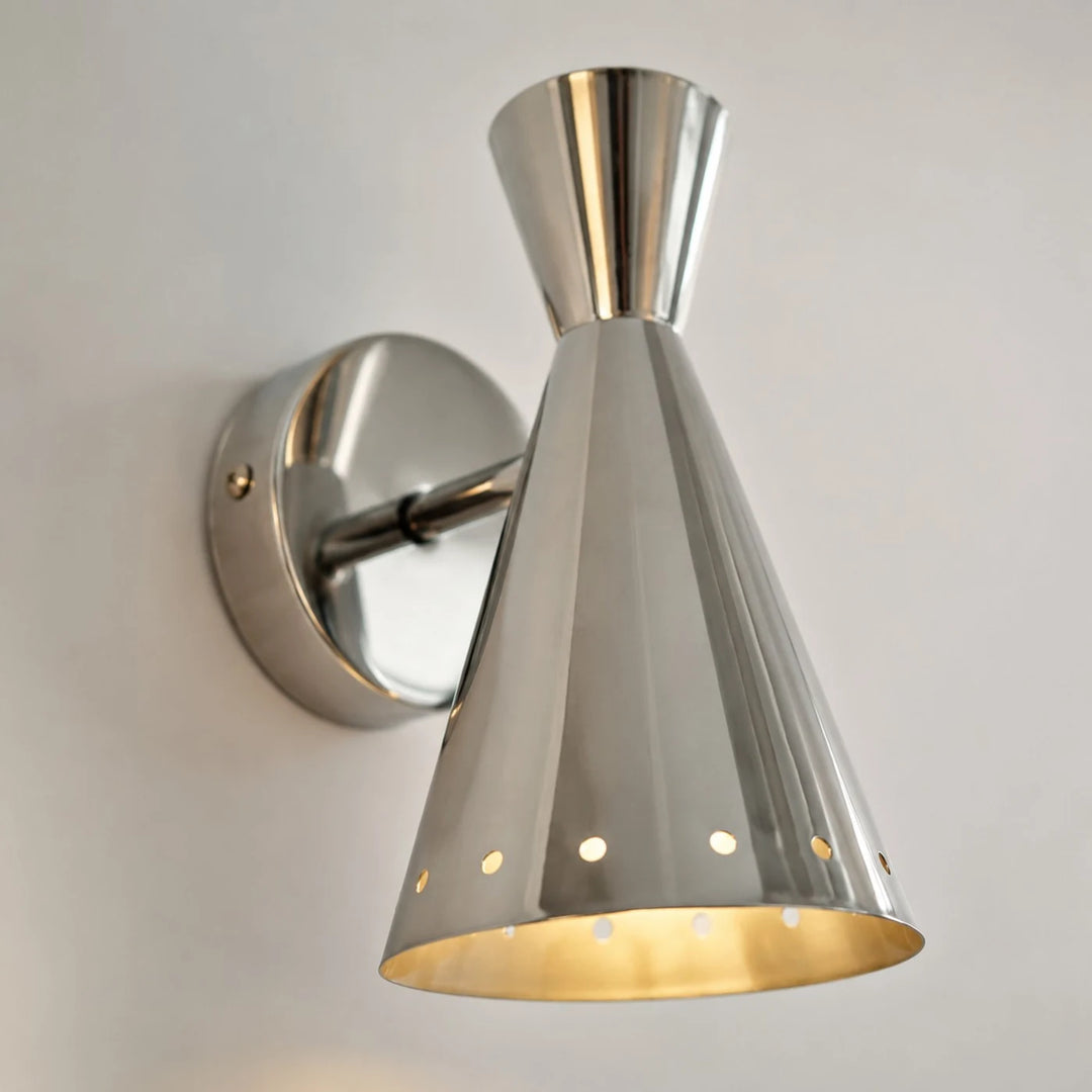 Close detail of polished metal cone shade and wall mount