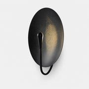 Black sculptural disc wall sconce