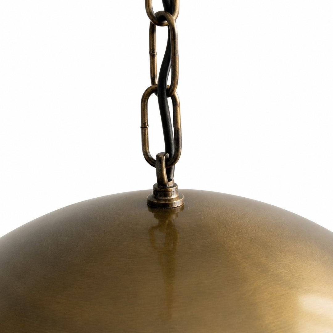 Antique brass pendant light in a warm dining room