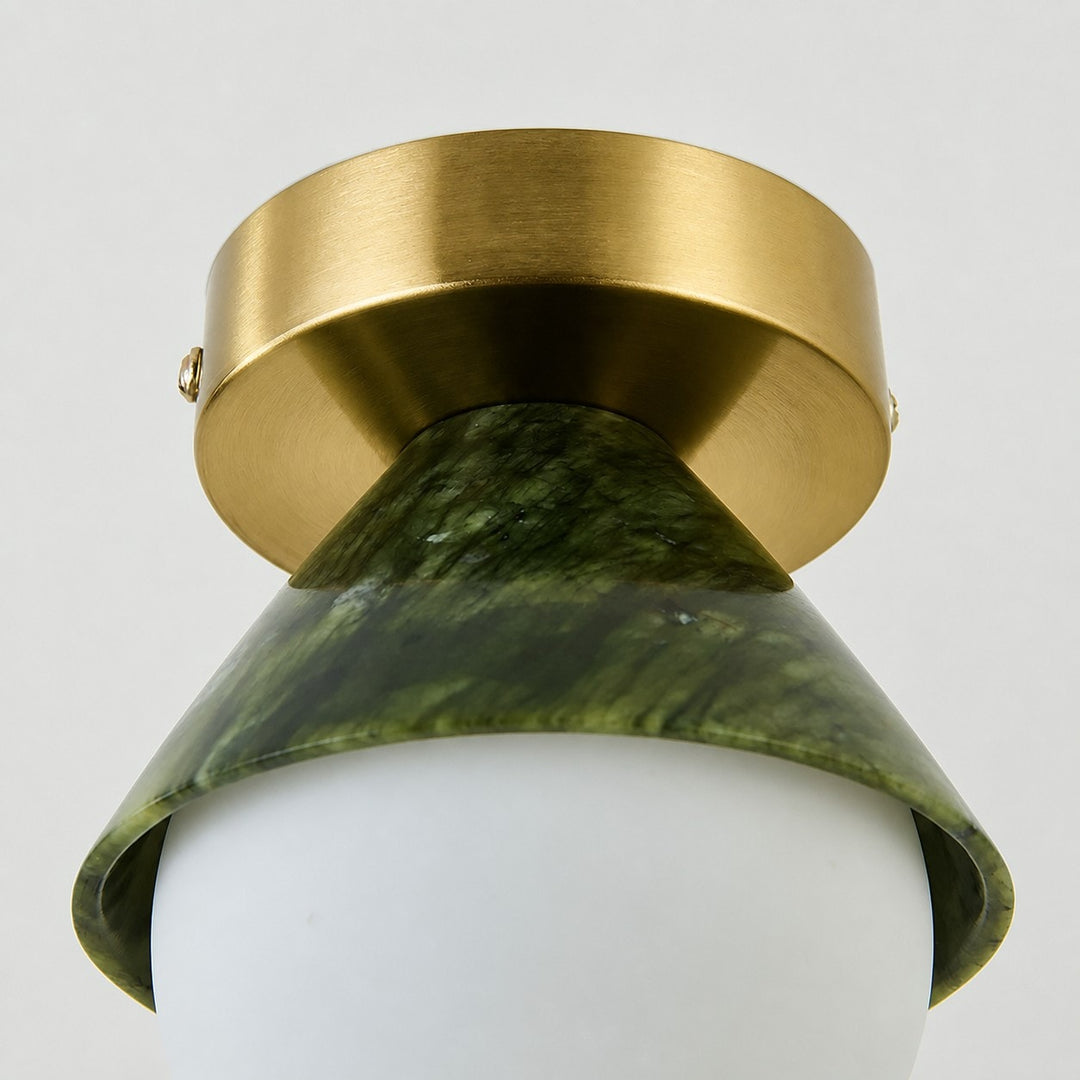 Close-up of brushed metal ceiling canopy and curved green shade