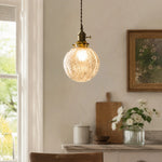 Load image into Gallery viewer, brass crackle glass pendant light glowing beside a bright window