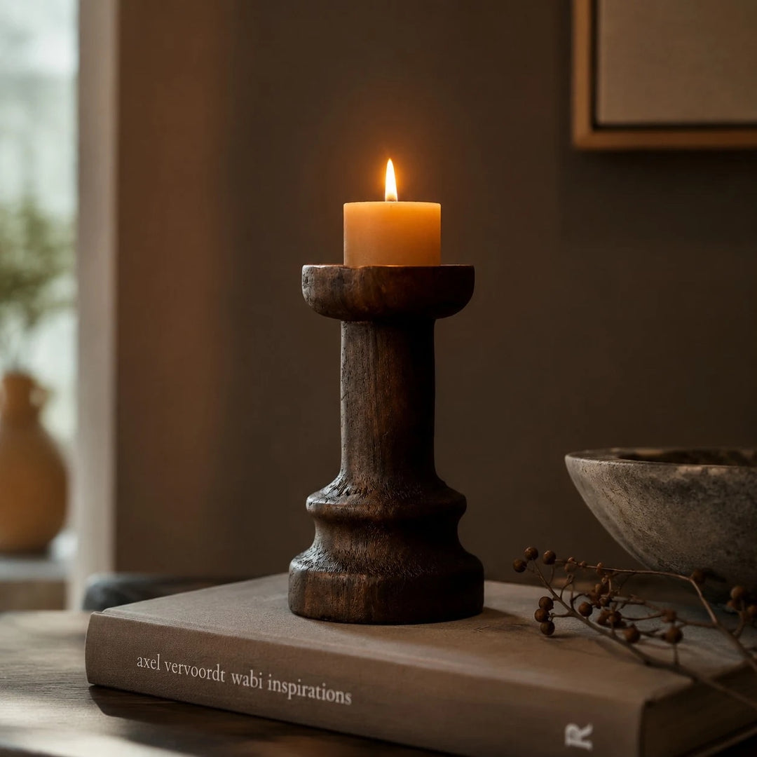 Solid wood candle holder styled on books in a warm interior; candle not included