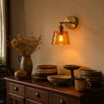Load image into Gallery viewer, Amber brass glass wall sconce above a console
