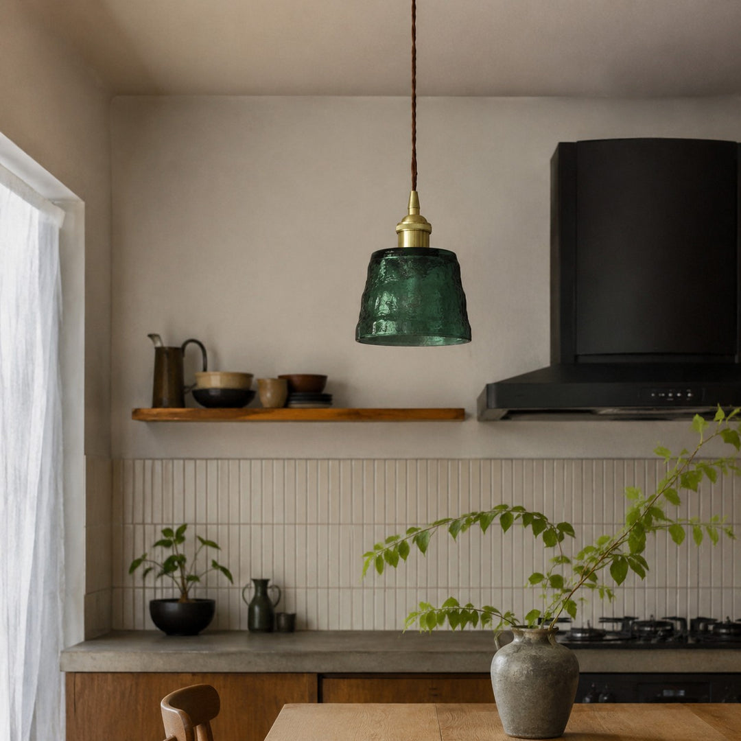 Green glass pendant light over a kitchen counter
