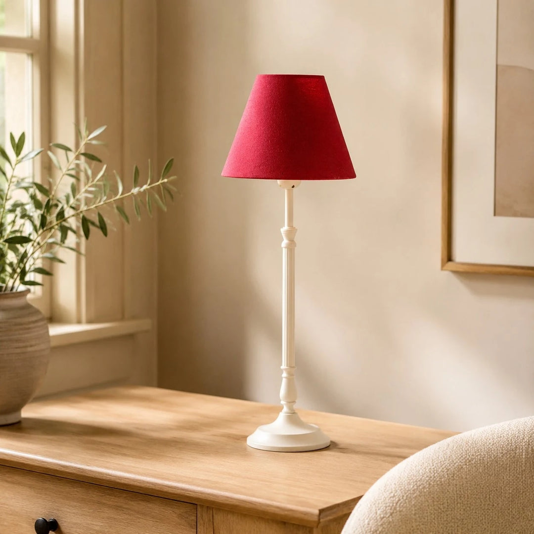 Rose red French country table lamp near a window