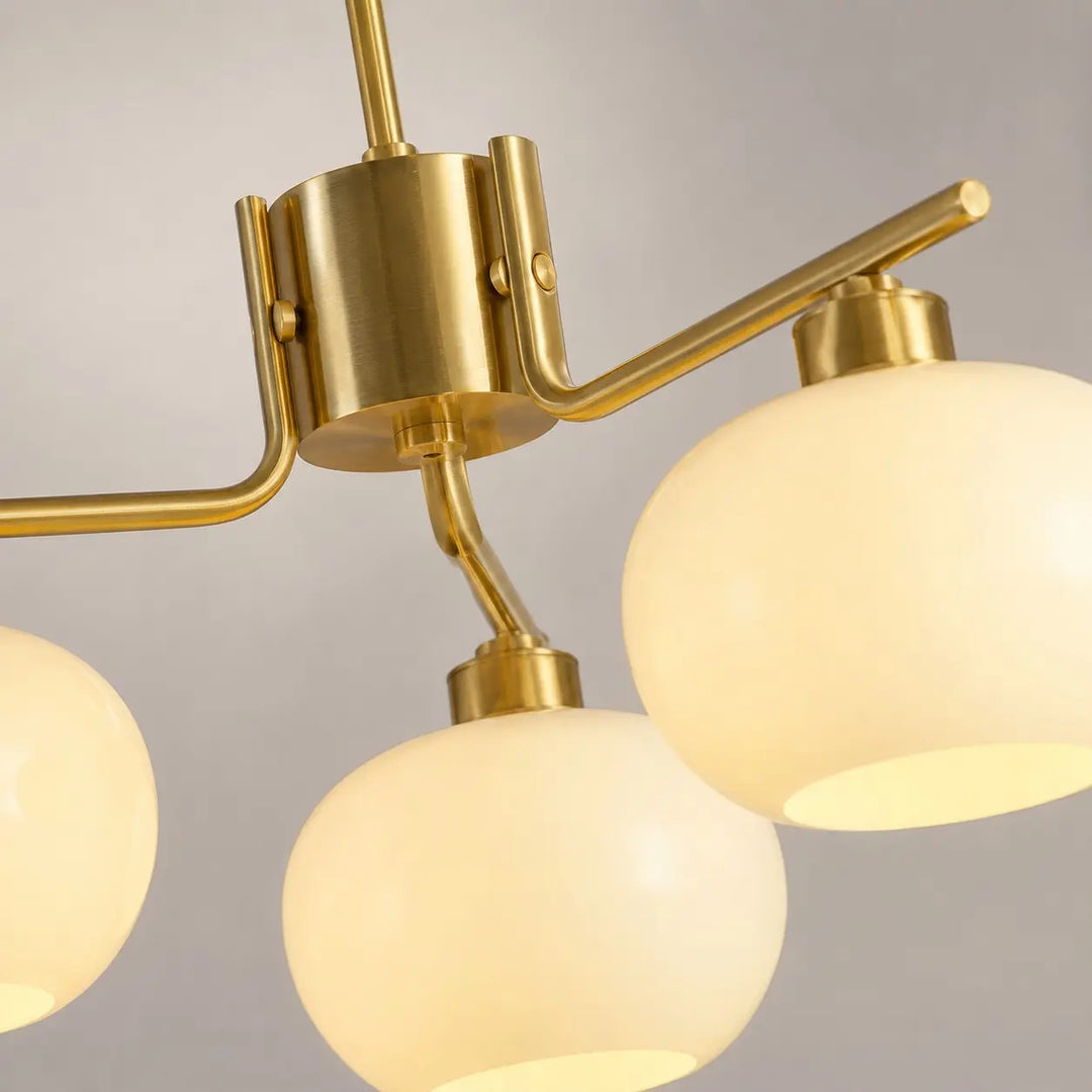 Gold chandelier arm connection and milk glass shade detail