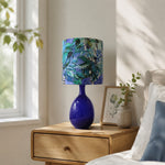 Load image into Gallery viewer, Green botanical fabric ceramic table lamp in a bedroom setting
