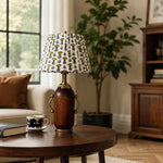 Load image into Gallery viewer, Deep brown floral table lamp styled beside a green armchair