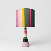 Colorful striped fabric table lamp with cotton thread wrapped ceramic base on white background