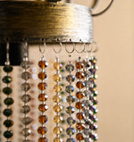 Cargar imagen en el visor de la Galería, Close-up of curved black iron frame on crystal pendant light
