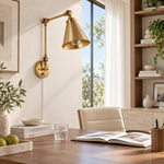 Load image into Gallery viewer, Gold swing-arm sconce above a desk in daylight